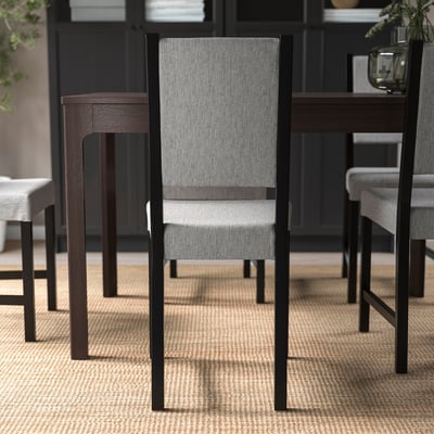 Moderne eetkamerstoel met gestoffeerde zitting en rugleuning, met stevig houten frame.