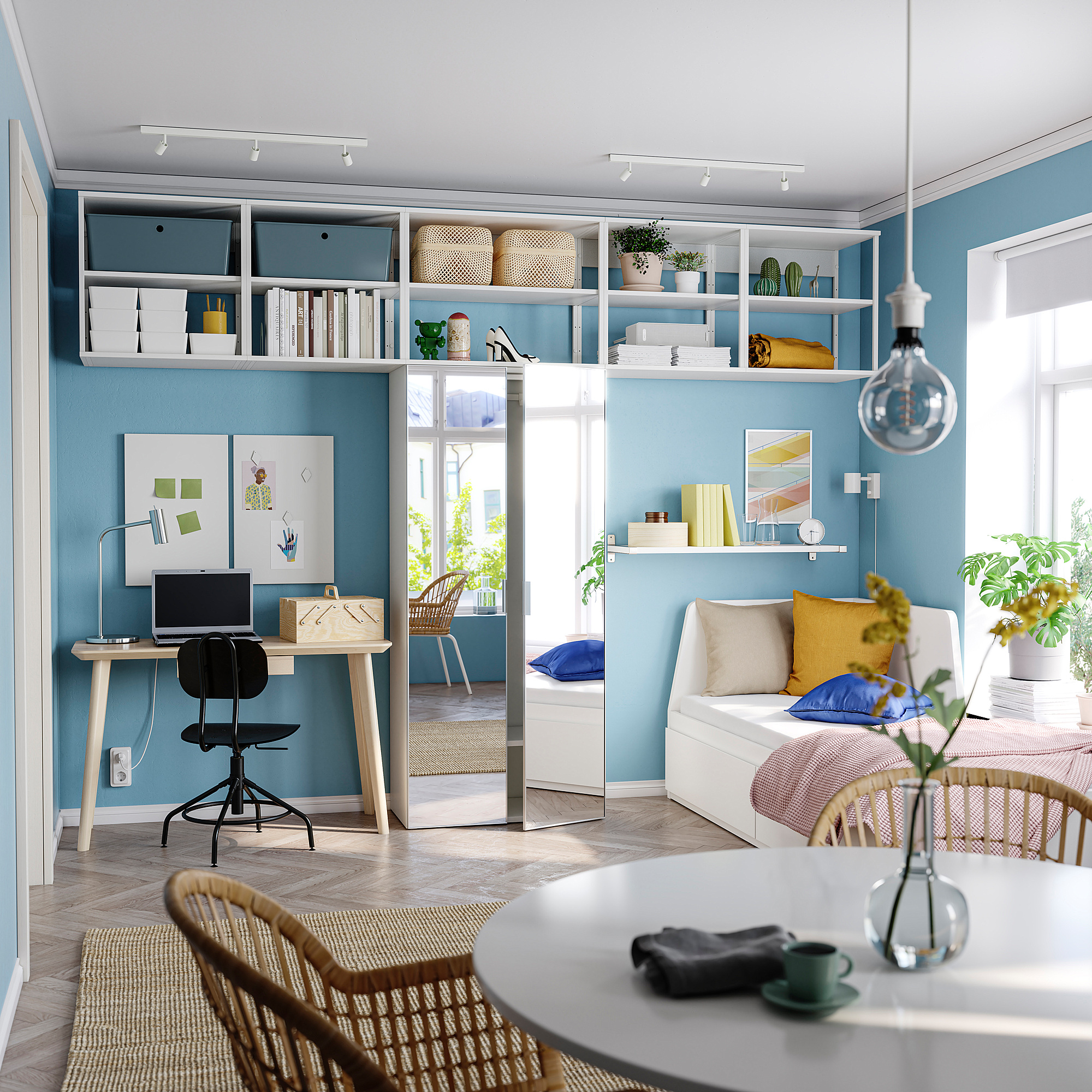 Moderne blauwe kamer met witte meubels, houten bureau, zwarte stoel, witte planken en grote spiegeldeur.