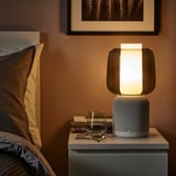 SYMFONISK luidsprekerlamp op nachtkastje, verlicht, bij bed en glas.