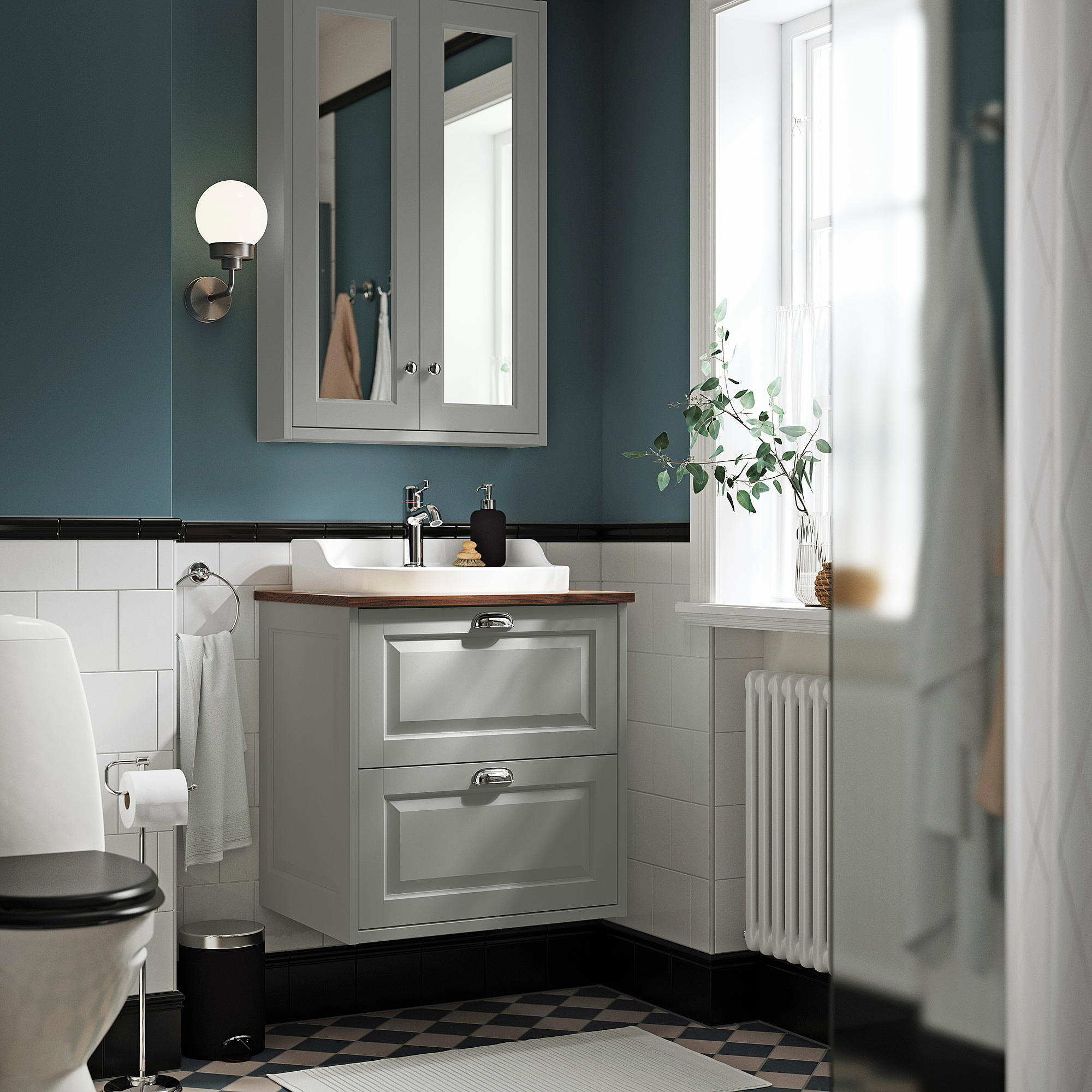 Moderne grijze badkameropstelling. Inclusief wandkast, wastafel, toilet en radiator. Geruite vloer.