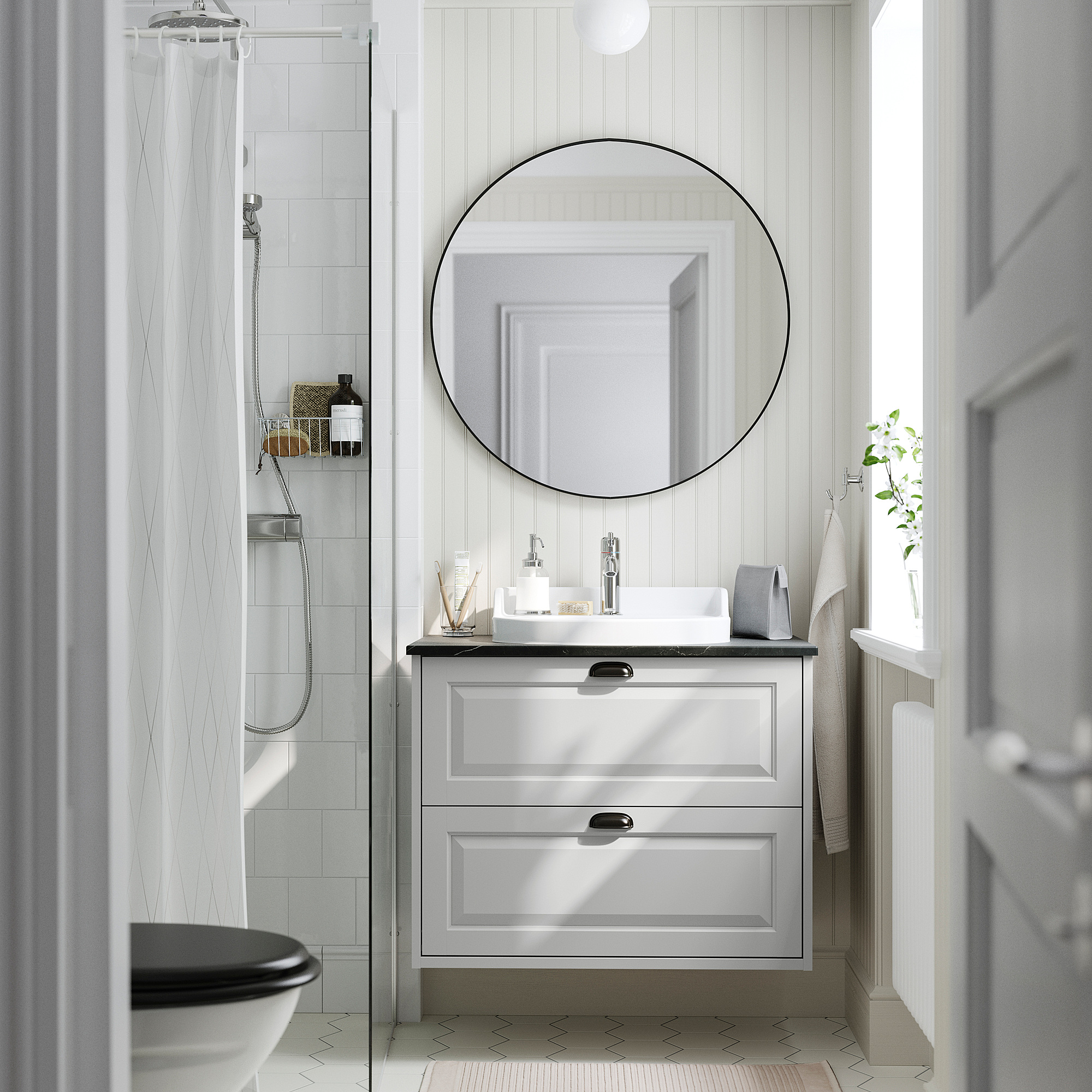 Moderne grijze badkamermeubel, ronde spiegel, witte wastafel en toilet. Tegels & douche.