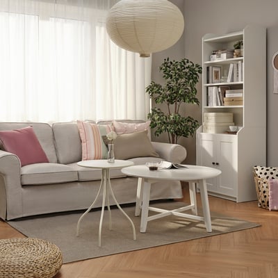 Gezellige woonkamer met TÅNEBRO bijzettafel. Klein, rond, gepoedercoat staal, in de buurt van grijze bank, met koffiekopje.