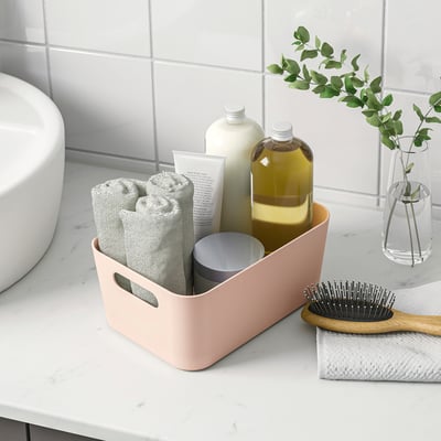 Badkamer organizer met handdoeken, flessen, borstel.