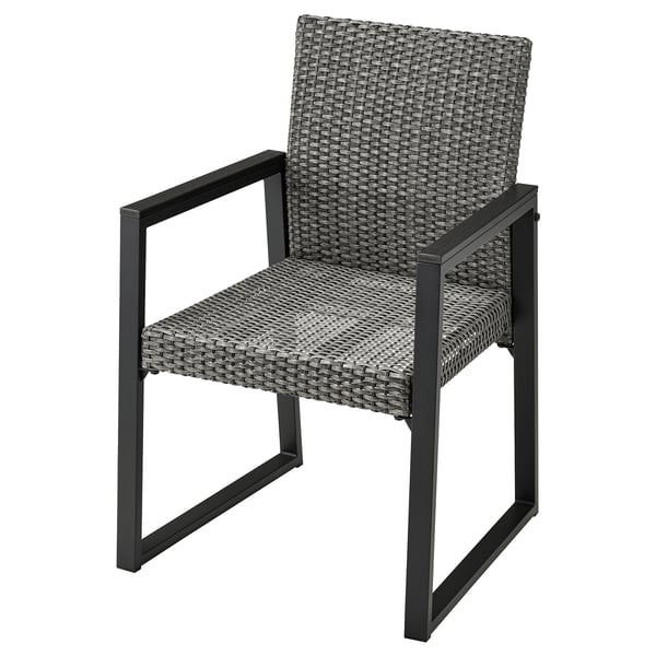 Een grijze VÄRMANSÖ terrasstoel met een rieten zitting en rugleuning, zwart metalen frame, armleuningen en strak design.