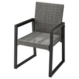 Een grijze VÄRMANSÖ terrasstoel met een rieten zitting en rugleuning, zwart metalen frame, armleuningen en strak design.