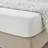 Bed met wit, donker gebloemd VÅRVIAL laken.