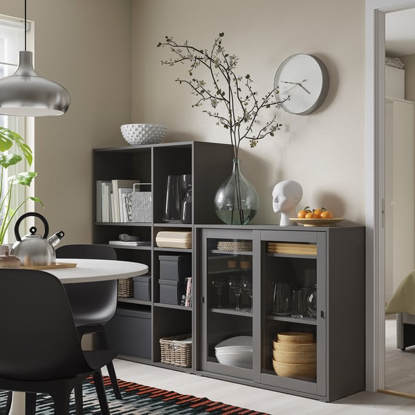 Opbergmeubel met zwarte glazen deur in de eethoek, met glazen, kommen en decoraties.