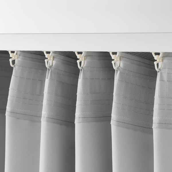 Close-up van VILBORG-gordijnen met haken, met geplooide stof en kamerverduisterende textuur.