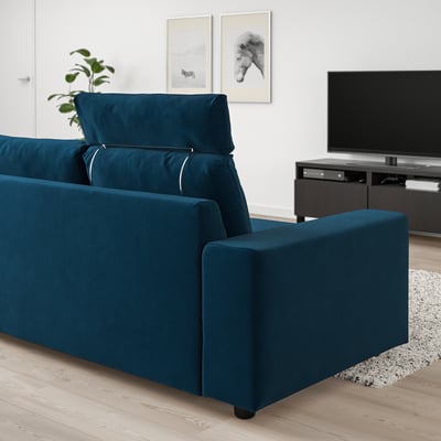 Blauwe VIMLE bank in moderne woonkamer. Geplaatst tegen witte muur, vlakbij tv.