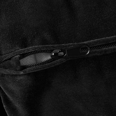 Close-up van zwarte stof met gladde textuur en hoogwaardige ritsdetails.