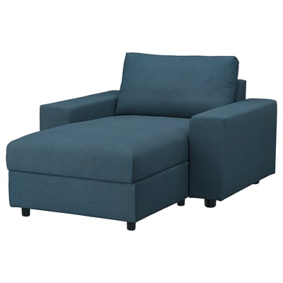 Blauwe stoffen fauteuil met schuine zitting en rugleuning, vier donkere poten, modern design.