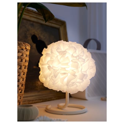 Een VINDKAST lamp. Het is wit, bolvormig en gemaakt van gerecycled polyester. De basis is gebogen, strak en minimalistisch.