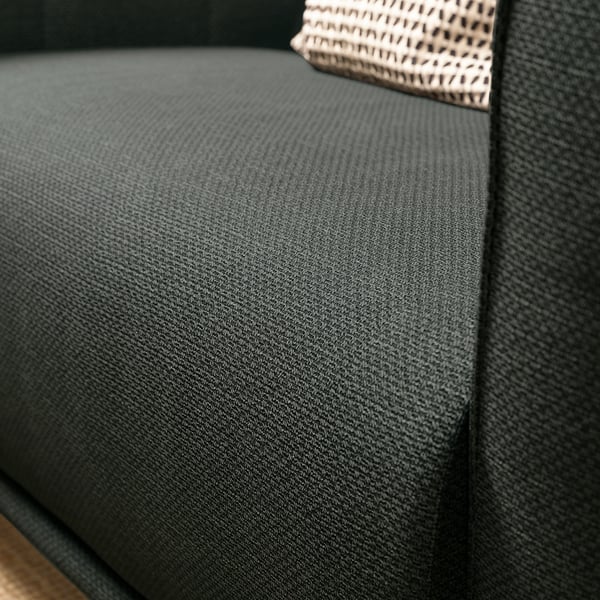 Donkergrijze VISKAFORS fauteuil close-up, gladde stofstructuur.