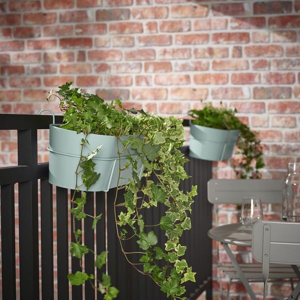 VITLÖK groene plantenpotten hangen aan zwarte balkonrail, kleine bloemen.