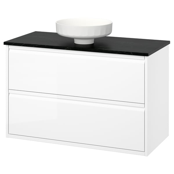 A white ÄNGSJÖN bathroom vanity with a sleek black countertop and round ceramic basin. It has smooth, modern lines and minimalist design.
