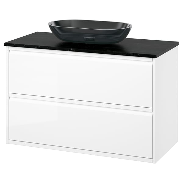 Modern white bathroom vanity, black marble countertop, and glass bowl sink.