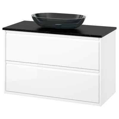 Modern white bathroom vanity, black marble countertop, and glass bowl sink.