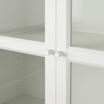 Clean white cabinet with glass doors, adjustable hinges, and empty shelves.