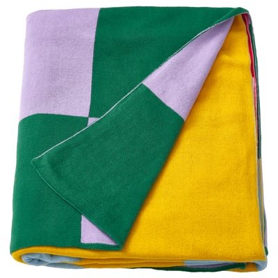 Colourful geometric blanket with stripes and circles. Yellow, pink, green, and red patterns. Cotton material, square shape.