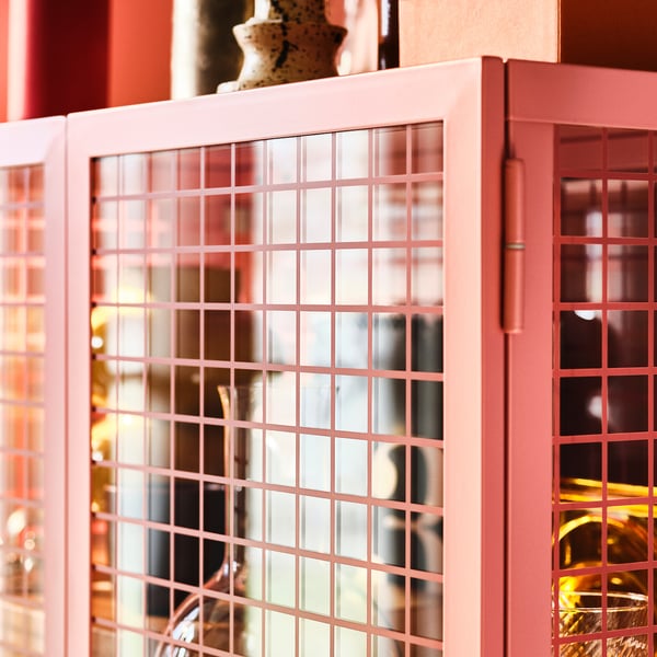 Pink IKEA glass door cabinet with grid pattern; shows items inside.