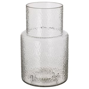 A KONSTFULL vase, clear with textured glass, designed by ilse crawford. It has a tall, cylindrical shape with a narrower neck, ideal for flowers.