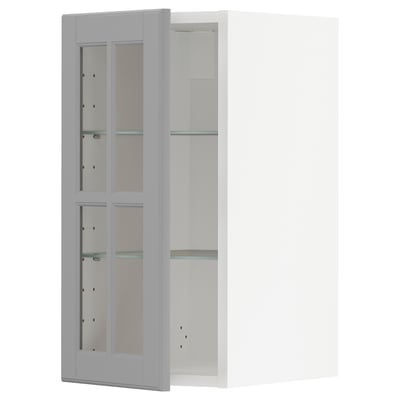 A white METOD kitchen cabinet with grey-tinted glass doors and adjustable glass shelves.