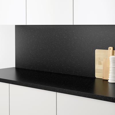Black speckled kitchen worktop with matching wall panel, clean and modern design.
