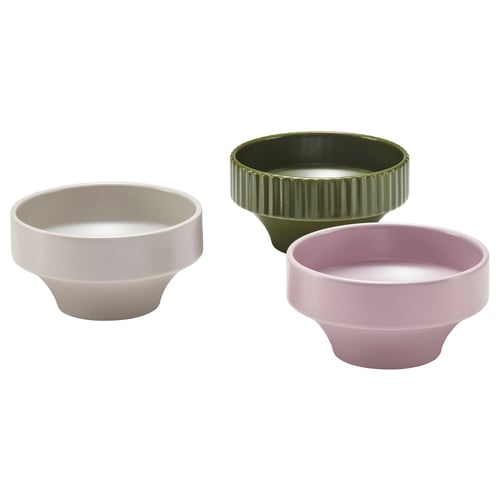 Three colourful ceramic bowls displayed; one beige, one olive green, one light purple, featuring unique outward flaring design.
