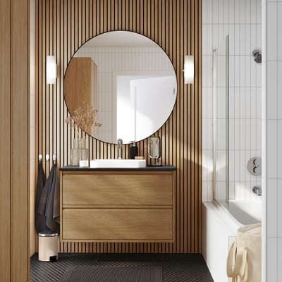 Modern bathroom: wooden ÄNGSJÖN vanity, round mirror, white tiles, glass shower.