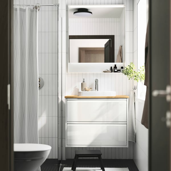 Modern ÄNGSJÖN wash-stand with bamboo countertop, semi-recessed marble basin, and drawers.