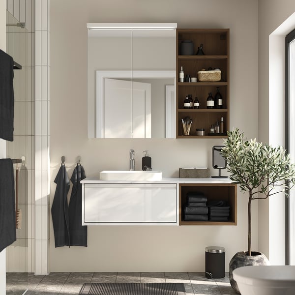 Modern bathroom with ÄNGSJÖN vanity, marble sink, mirror cabinet, olive plant, and dark towels.