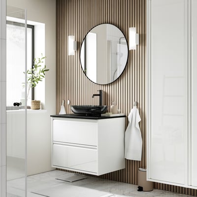 Modern bathroom with white ÄNGSJÖN vanity, glass basin, round mirror, wall-mounted for airy feel.