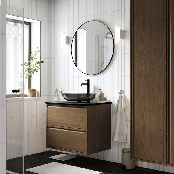 Modern bathroom with brown oak ÄNGSJÖN sink, round mirror, and minimalist design.
