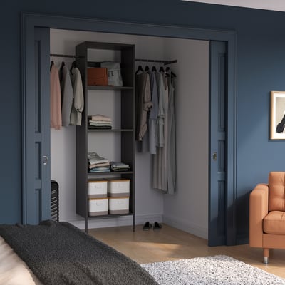 Modern AURDAL storage in room, black & grey, shelves with clothes & rug.