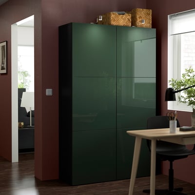 Green BESTÅ storage unit against wall, with baskets, fits room.