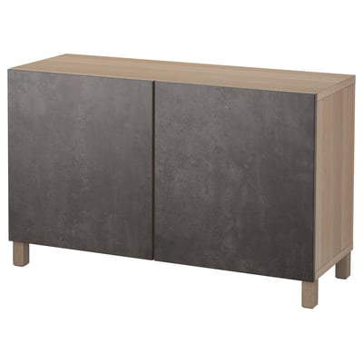 An IKEA BESTÅ sideboard with two large grey doors and a light wood top and frame. It has a modern design with clean lines and stands on wooden legs.