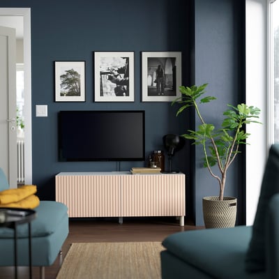 Modern living room with BESTÅ, plant, turquoise seating, dark walls.