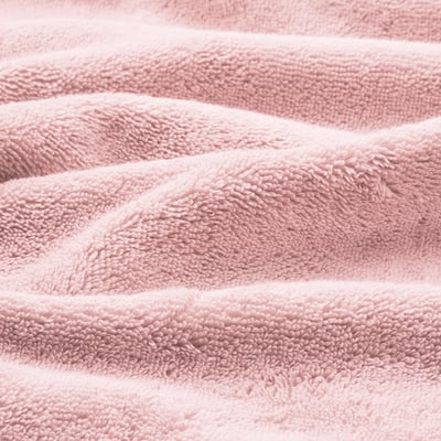 BROKGLIM light pink towel, soft organic cotton, folded neatly with a decorative border.