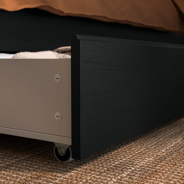 Black bed storage box with wheels, fitting under FÅGELFJÄLLET bed frame for easy access and organisation.