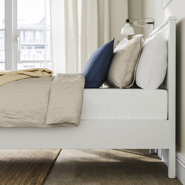 Bed with striped pillows, nightlight, and blanket. GULLABERG style with slatted base, storage space, and supportive headboard.