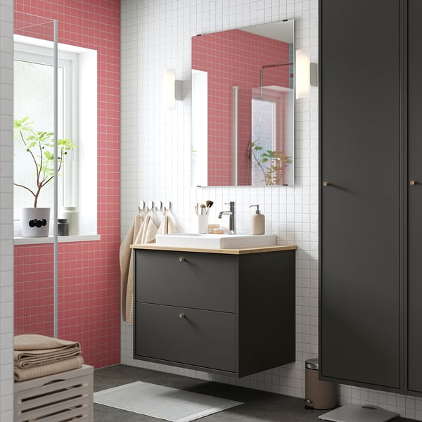 Modern bathroom with red & white tiles, grey HAVBÄCK vanity, bamboo countertop & ceramic basin.