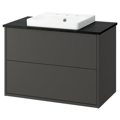 Modern black bathroom vanity with sleek drawers and white basin.
