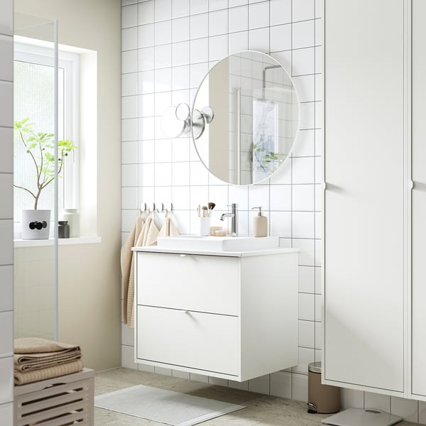 White HAVBÄCK bathroom vanity with floating design, large countertop, and round mirror.
