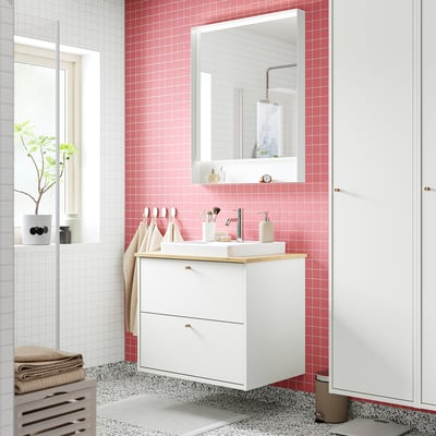 White HAVBÄCK cabinet, wood counter, built-in sink. Mirror, tiles, towels.