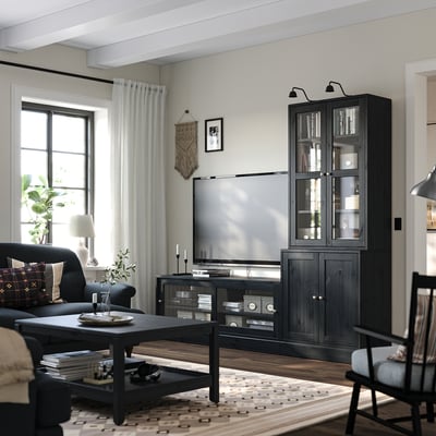 Modern living room with black HAVSTA tv unit and cabinet, large flat screen tv, cosy seating, and decorative elements.