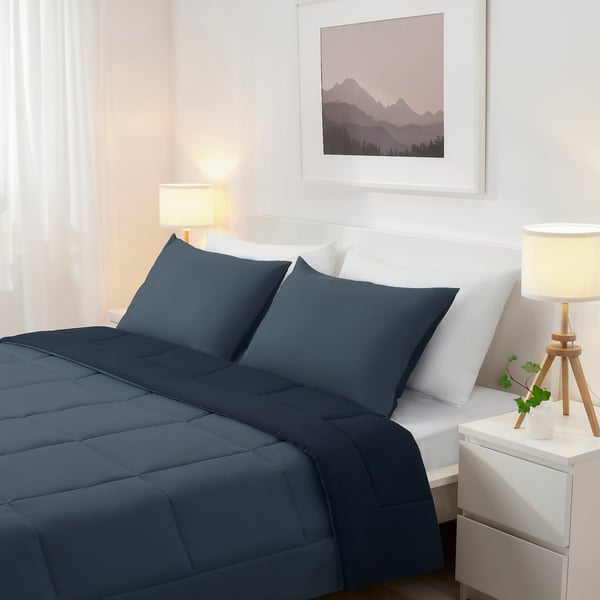 Bedroom with HEDFRYLE dark blue comforter & pillow, simple lamps, plant, mountain print.