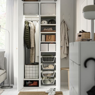 Open closet with organised clothes, accessories, and shoes. Baskets on right, hanging garments and folded clothes on left.