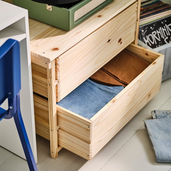 Wooden chest with drawers, one open showing blue fabric lining, likely for storage, simple scandinavian design.