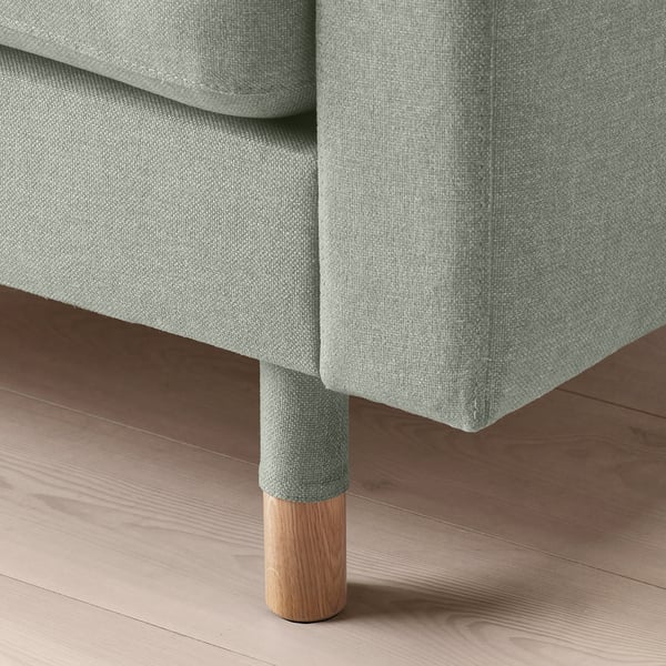 Modern sofa with plush upholstery, wooden legs. Soft, stylish design.