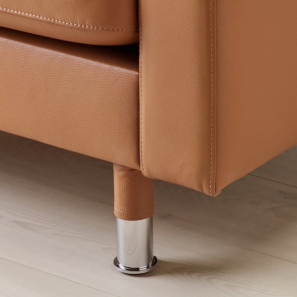 Close-up of brown leather sofa leg, showcasing quality stitching and chrome base.